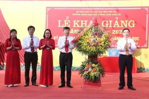 Ông Bùi Huy Vĩnh - Phó Bí thư Tỉnh ủy Phú Thọ (thứ nhất bên phải) tặng hoa chúc mừng thầy và trò trường THPT Long Châu Sa.
