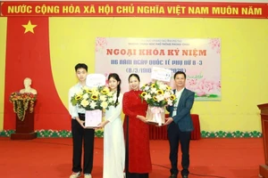 Ông Quách Thành Đô - Hiệu trưởng Trường THPT Phong Châu (thứ nhất bên phải) cùng nam sinh tặng hoa đại diện nữ giáo viên và nữ sinh nhà trường.