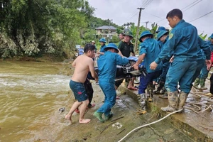 Lực lượng chức năng trục vớt xe máy của nạn nhân vụ nước lũ cuốn trôi.