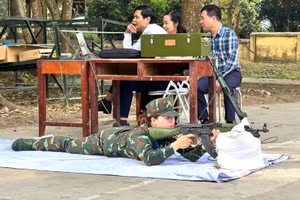 Giáo viên tham gia nội dung thi bắn súng tiểu liên AK bằng máy bắn tập.
