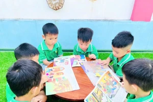 Các bé mẫu giáo 5 tuổi trường Mầm non Cao Xá 1 (xã Bản Nguyên) xem tranh truyện.