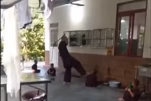Người đàn ông đánh trẻ bằng roi. (Ảnh cắt từ clip)
