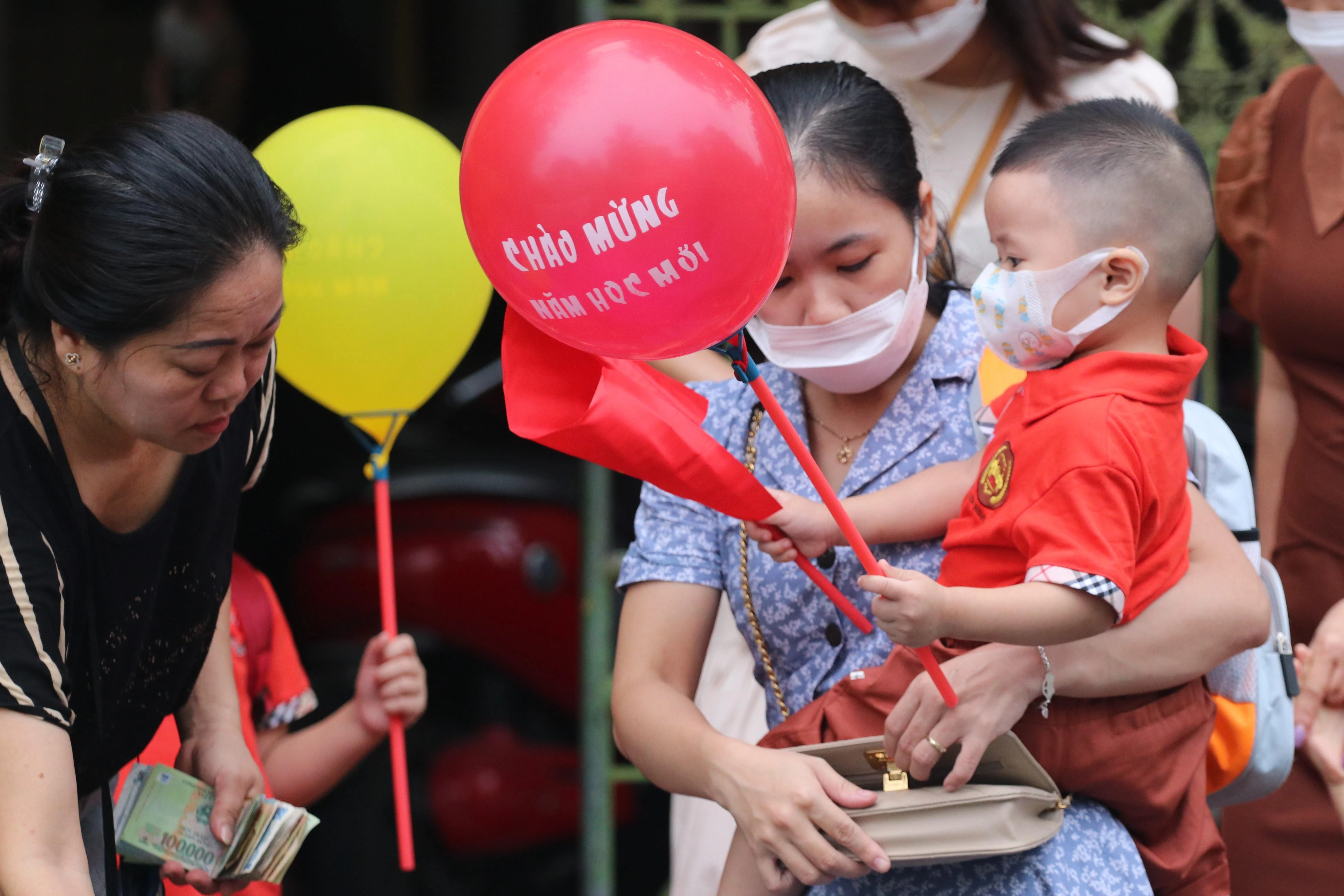Nhiều cháu nhỏ được bố mẹ mua bóng bay, cờ để dự lễ khai giảng năm học mới.