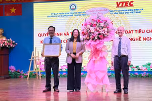 TS Trần Kim Tuyền, Hiệu trưởng Trường Cao đẳng nghề TPHCM (trái) đón nhận Giấy chứng nhận đạt chuẩn kiểm định chất lượng chu kỳ II.