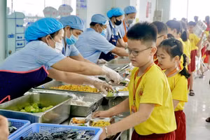 Học sinh Trường Tiểu học, THCS, THPT Nam Việt lấy khẩu phần ăn bán trú. Ảnh: NL.