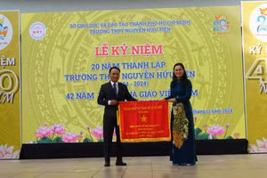 Bà Lê Thị Mỵ Châu tặng Cờ truyền thống cho nhà trường.