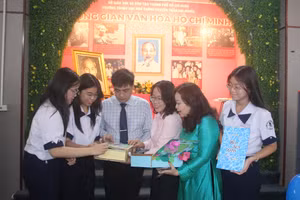 Lãnh đạo Ban Tuyên giáo Quận uỷ Quận 1, Trường THPT chuyên Trần Đại Nghĩa cùng cô Trần Kim Duyên và học trò xem các tác phẩm về Bác Hồ. 