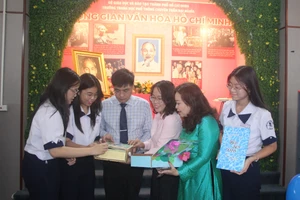 Lãnh đạo Ban Tuyên giáo Quận uỷ Quận 1, Trường THPT chuyên Trần Đại Nghĩa cùng cô Trần Kim Duyên và học trò xem các tác phẩm về Bác Hồ.