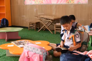 Học sinh Trường Tiểu học Đặng Trần Côn (Quận 4) đọc sách tại khuôn viên sân trường.