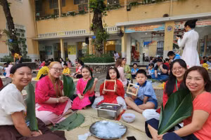 Học sinh, giáo viên và phụ huynh Trường Tiểu học Trần Hưng Đạo cùng nhau gói những chiếc bánh chưng xanh trong ngày hội "Gói Tết-Trao Xuân".