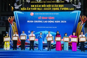 Bà Văn Thị Bạch Tuyết, Phó Bí thư Thành uỷ TPHCM trao Huân chương lao động hạng Nhì, Ba cho các nhà giáo.