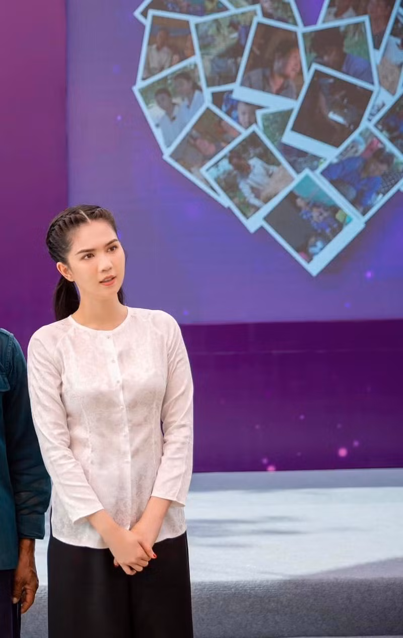 Nữ người mẫu diện trên mình bộ đồ bà ba giản dị, nền nã, mái tóc đen tết gọn gàng cùng kiểu trang điểm nhẹ nhàng nhưng vẫn rất nổi bật. Ngọc Trinh diện áo bà ba làm từ thiện, nhan sắc khiến người đối diện khen nức nở