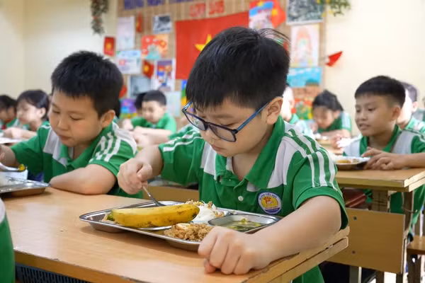 Học sinh tại Trường tiểu học Thanh Liệt, Hà Nội thưởng thức bữa trưa theo thực đơn. Ảnh: INT