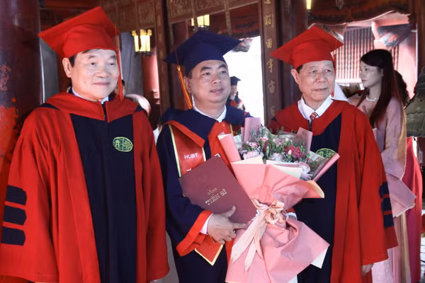 PGS.TS Phạm Dương Châu - Phó Hiệu trưởng phụ trách Trường ĐH Kinh doanh và Công nghệ Hà Nội; PGS, TS Phạm Văn Đăng - Phó Viện trưởng thường trực Viện đào tạo Sau đại học trao bằng và tặng hoa cho tân tiến sĩ, PGS.