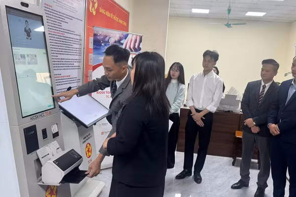 Đại diện đơn vị tài trợ và lãnh đạo UBND xã Nghĩa Trụ quan sát và hỗ trợ người dân đến trải nghiệm robot trong ngày 30/12. Ảnh: T.Đảng