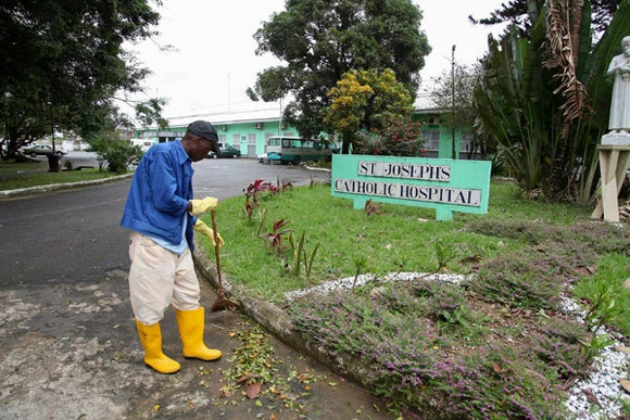 Một y tá đang quét dọn bên ngoài bệnh viện St.Joseph, Monrovia, Liberia. Bệnh viện này đã bị đóng cửa do dịch Ebola bùng phát. Ảnh: NYTimes