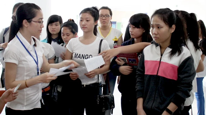 Thí sinh chỉnh sửa sai sót trên giấy báo thi chuẩn bị dự thi ĐH đợt 2 năm 2014. Ảnh - Minh Giảng