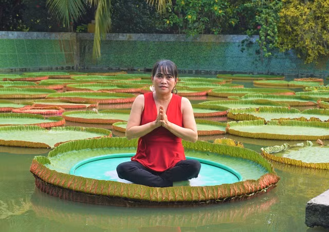 Du khách thích thú khi lần đầu tiên được trải nghiệm ngồi trên lá sen khổng lồ (Ảnh: Bảo Kỳ).