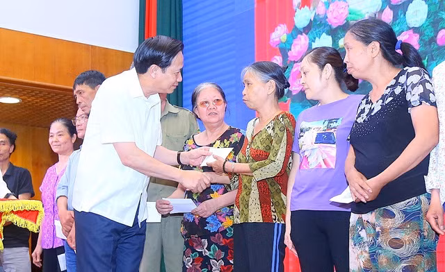 Bộ trưởng Đào Ngọc Dung trao tiền hỗ trợ từ gói 62.000 tỷ đồng tới người lao động tại quận Hà Đông. (Ảnh: Toàn Vũ)