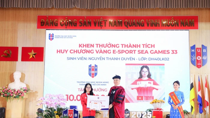 GS.TS Nguyễn Đức Trung, Hiệu trưởng Trường Đại học Ngân hàng TPHCM, trao phần thưởng của nhà trường cho Nguyễn Thanh Duyên. Ảnh: HUB
