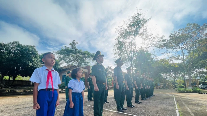 Hai em Tuấn và Tuyền thực hiện nghi thức chào cờ cùng các chú bộ đội.