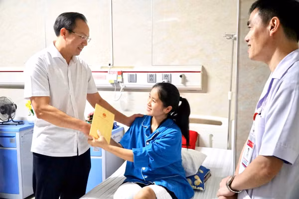 Thứ trưởng Bộ GD&ĐT Đoàn Trung Kiên thăm hỏi, động viên cô giáo Hoàng Thị Hiền đang điều trị tại Bệnh viện Đa khoa Cửa Đông (Nghệ An). Ảnh: Hồ Lài