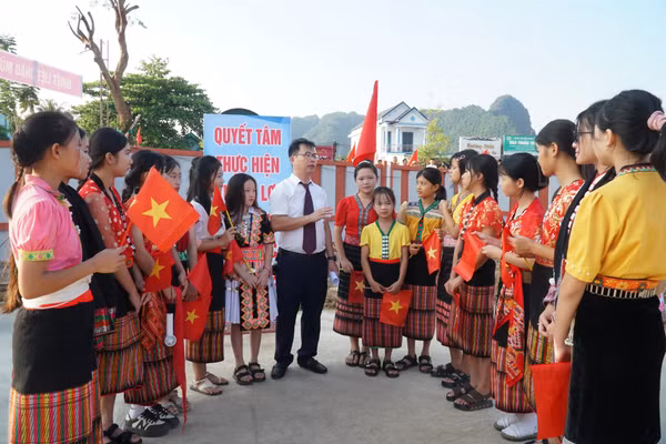 Thầy Nguyễn Lê Tú - giáo viên Trường Phổ thông nội trú TH&THCS Anh Sơn (Nghệ An) đón học sinh từ bản Cao Vều. Ảnh: Hồ Lài