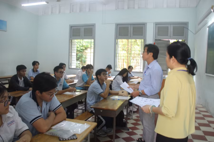 Thí sinh tại điểm thi Trường THPT chuyên Lê Hồng Phong (quận 5) nghe cán bộ phổ biến quy chế thi chiều 26/6.
