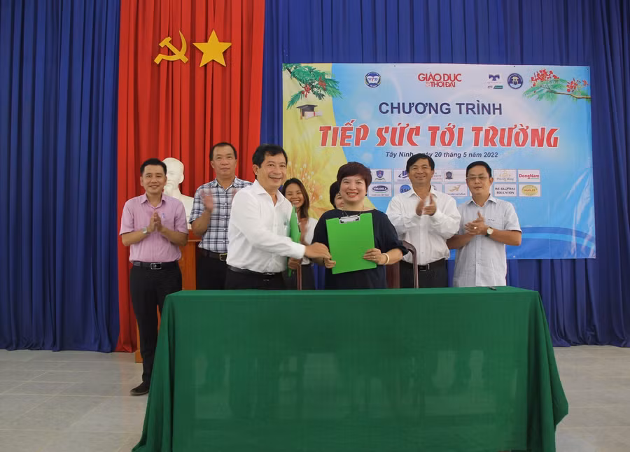 Nhà báo Dương Thanh Hương và ông Phạm Ngọc Hải trao văn bản ký kết.