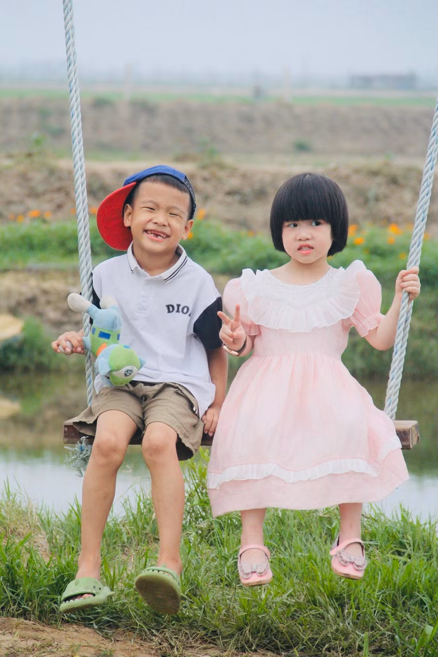 Đôi bạn nhỏ tạo dáng với xích đu. Đôi bạn nhỏ tạo dáng với xích đu.