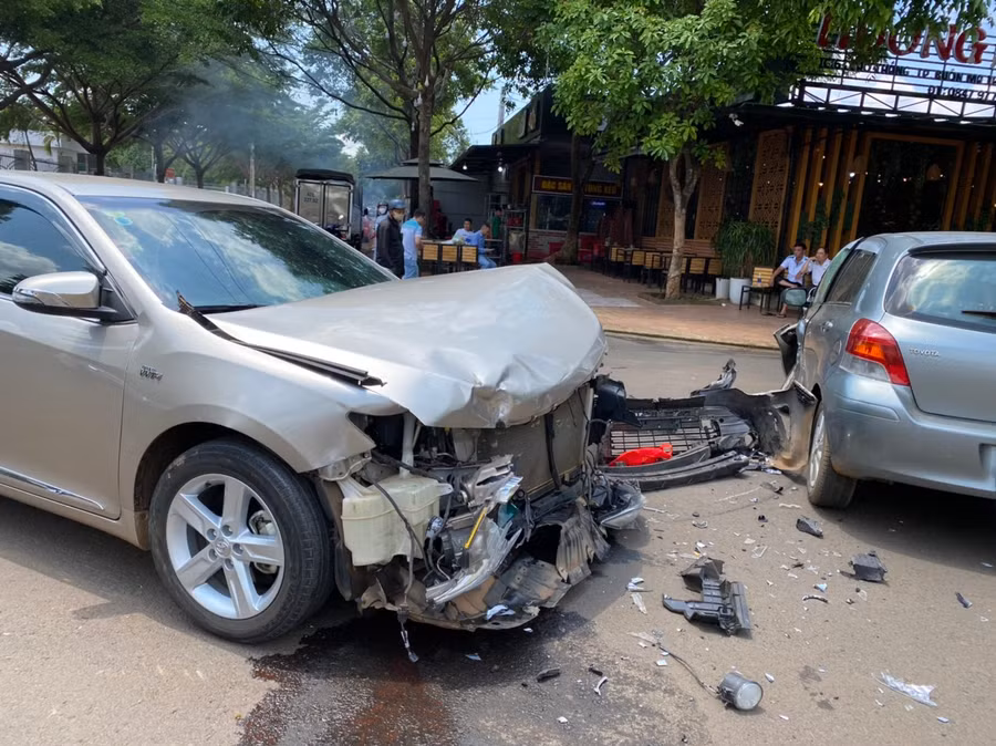 Phần đầu xe Camry bị tông nát bét, một số bộ phận bị rơi ra ngoài.