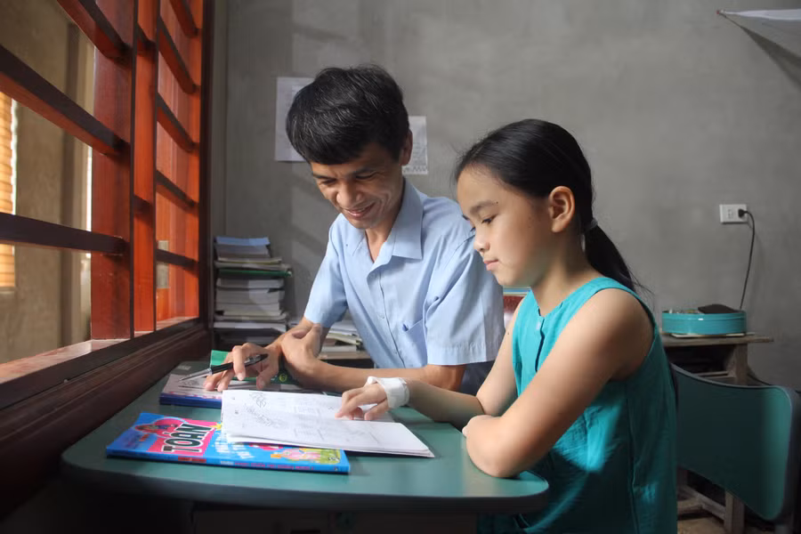 Sau những giờ dạy trên lớp, niềm vui của thầy Phi là kèm cặp việc học của các con.