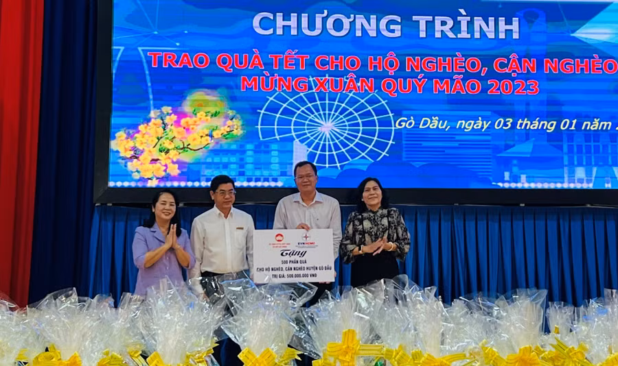 Bà Trần Kim Yến và đại diện nhà tài trợ trao biển tượng trưng 500 phần quà cho chính quyền huyện Gò Dầu.