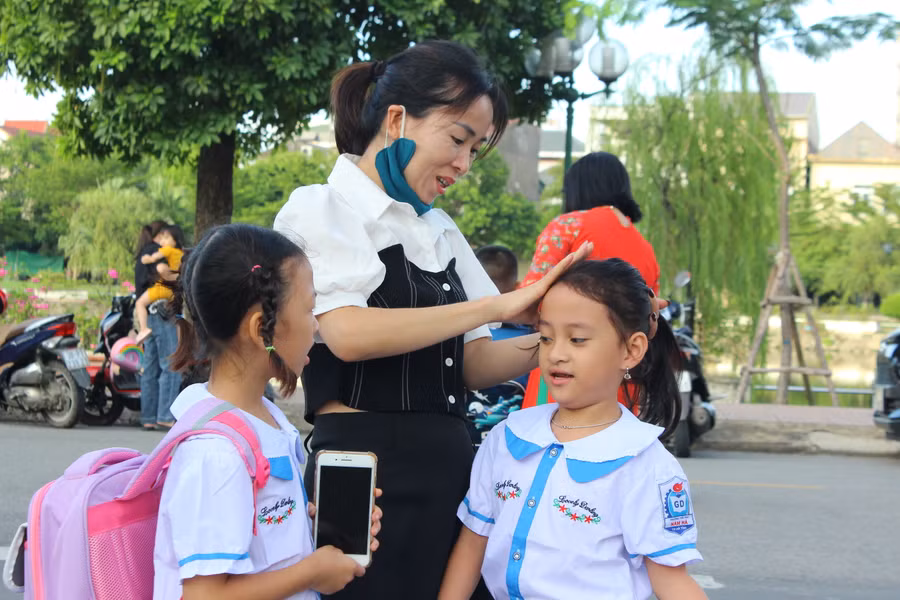 Phụ huynh sửa soạn cho con trước khi bước vào trường.