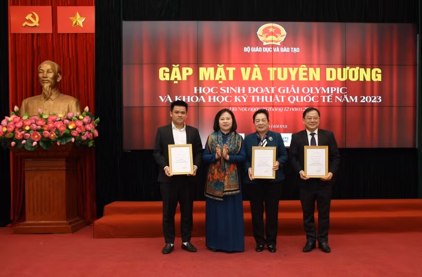 Thứ trưởng Bộ Giáo dục và Đào tạo Ngô Thị Minh trao bằng khen Lê Đình Lực (trái) - Ảnh: NVCC.