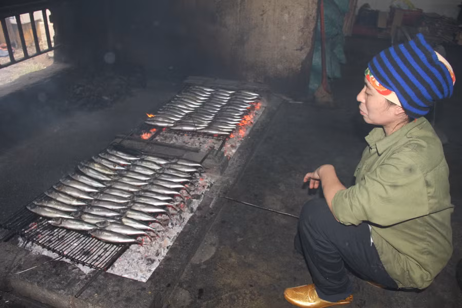 Bà Nguyễn Thị Thương trở đều tay mẻ cá nướng trên bếp than củi.