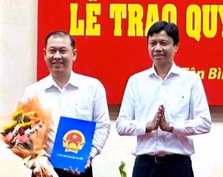 Ông Nguyễn Bá Thành, chủ tịch UBND quận Tân Bình trao quyết định bổ nhiệm Trưởng phòng GD&ĐT cho ông Phan Văn Quang (trái). Ảnh: GIA HUY.