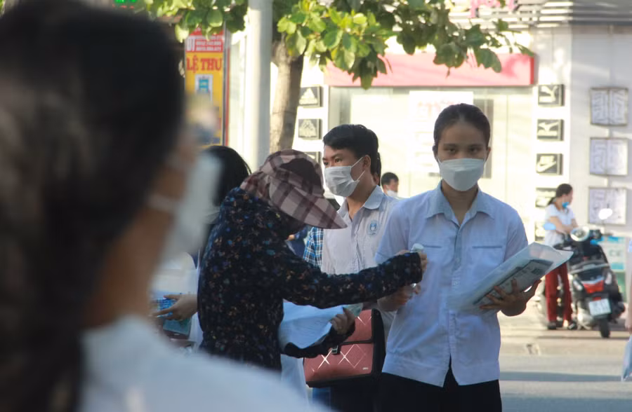 Một phụ huynh cẩn thận kiểm tra lại tư trang của thí sinh trước khi vào HĐT.