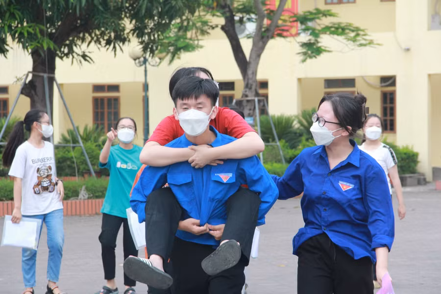 Một thí sinh bị đau chân được tình nguyện viên hỗ trợ trong chiều nay.