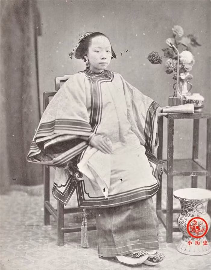 Một phụ nữ người Khách Gia (hay còn gọi là người Hẹ). Tay trái của cô đang cầm một quyển sách, đây là tư thế quen thuộc khi chụp ảnh trong phòng chụp ảnh cuối thời nhà Thanh.