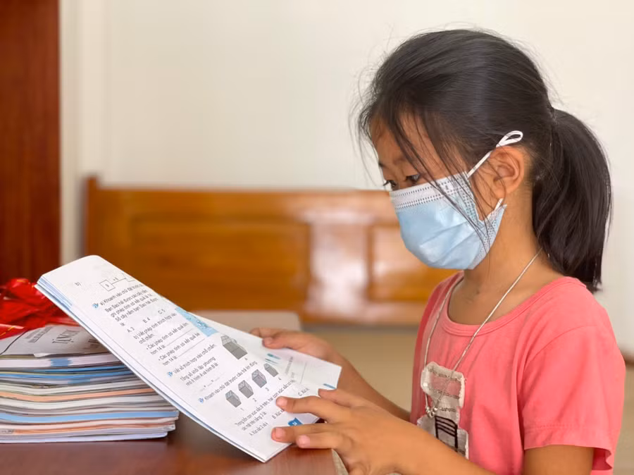 Em Phan Thị Huyền Trang (lớp 2, con út chị Hải) khấp khởi trước bộ sách giáo khoa và bàn học mới vừa được trao tặng. "Cháu thích ngôi nhà mới lắm. Mùa mưa này cháu không sợ bị dột hay ướt sách vở như trước nữa rồi", Huyền Trang chia sẻ.
