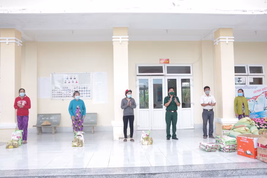Cán bộ đồn Biên phòng An Thạnh Ba tặng quà cho các hộ gia đình có hoàn cảnh khó khăn bị ảnh hưởng dịch Covid-19.
