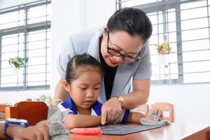 Thứ trưởng Nguyễn Thị Quyên Thanh ân cần hướng dẫn học sinh vùng biên An Giang đọc từng con số trên bảng.