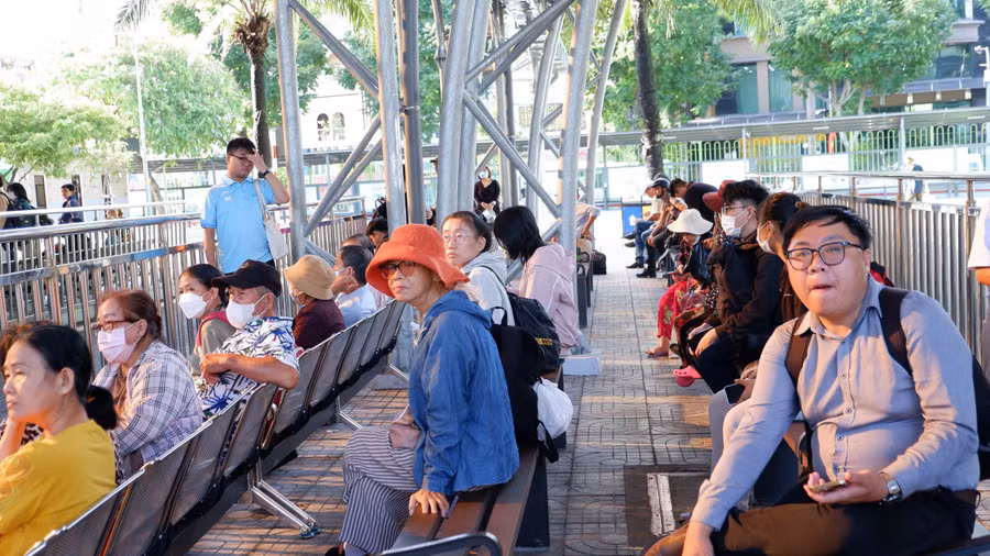 Người dân TPHCM chờ xe buýt sáng 1/7. Ảnh: Hữu Huy. 
