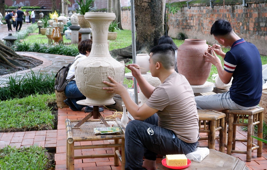 Các nghệ nhân trực tiếp vẽ gốm tại buổi trưng bày. gom-4.jpg