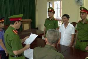Cơ quan điều tra tống đạt các quyết định đối với Nguyễn Thế Bảo (áo trắng).