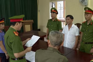 Cơ quan điều tra tống đạt các quyết định đối với Nguyễn Thế Bảo (áo trắng).