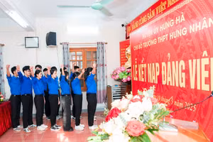 Đảng viên trẻ Trường THPT Hưng Nhân tuyên thệ trước cờ Đảng, cờ Tổ quốc và chân dung Chủ tịch Hồ Chí Minh.
