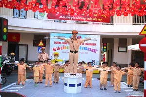Các em nhỏ được cán bộ Phòng CSGT hướng dẫn thực hành làm CSGT nhí.