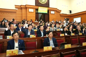 Các đại biểu biểu quyết thông qua nghị quyết tại kỳ họp. Ảnh Tất Đạt